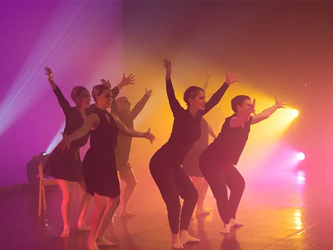 dancers on stage with colored lighting