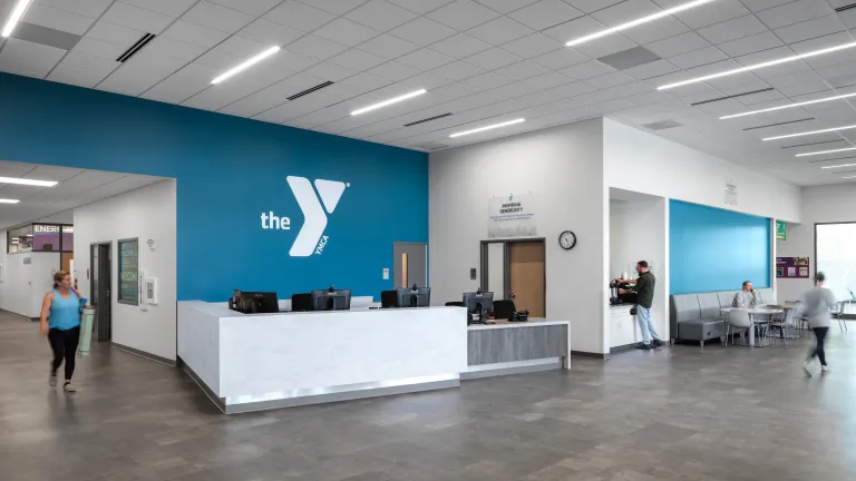 lobby with desk, seating, and blue accent logo wall