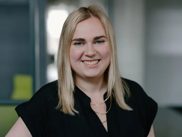 woman with straight blonde hair and black blouse