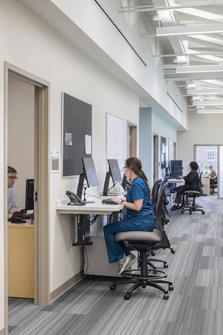 woman sits at desk in medical office building workspace