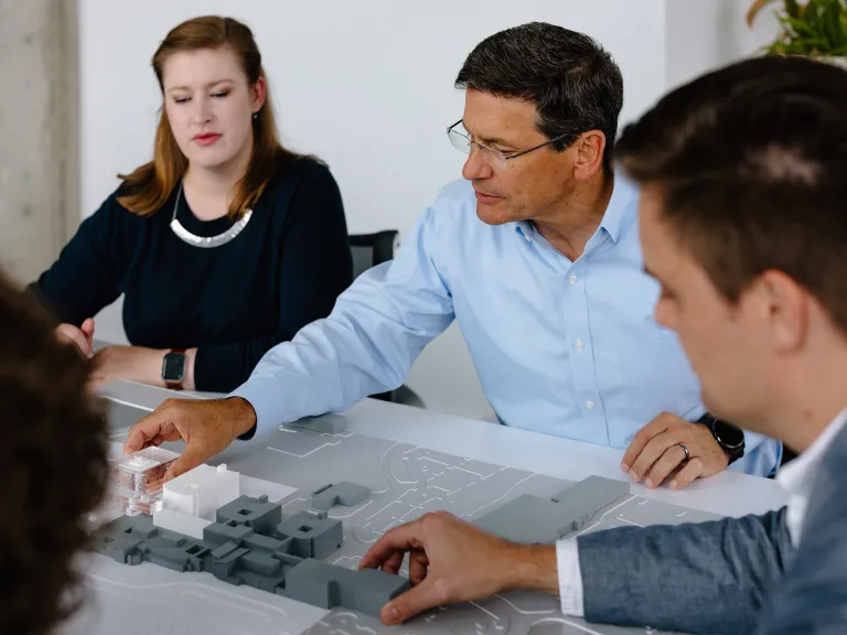 The DesignGroup team around a table discussing a planning model.