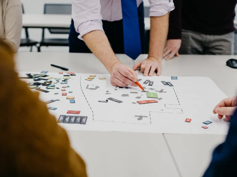 Group of people at a table working on planning documents.
