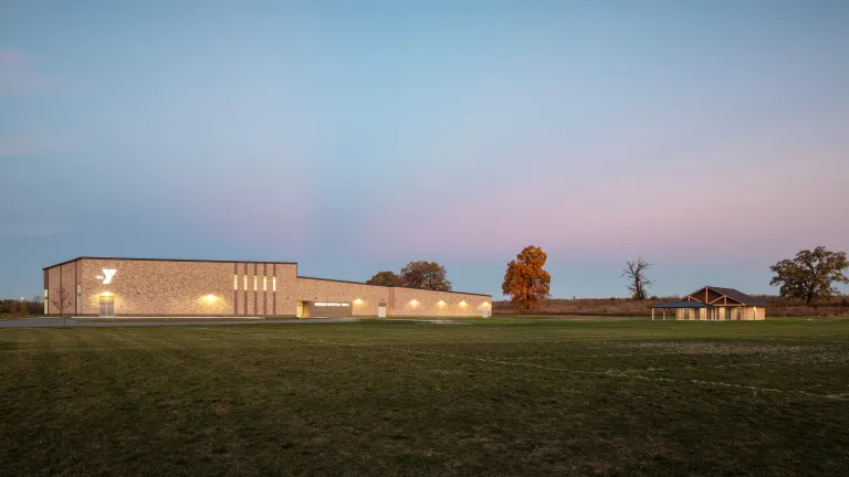 tan brick building and wooden pavilion at dusk 