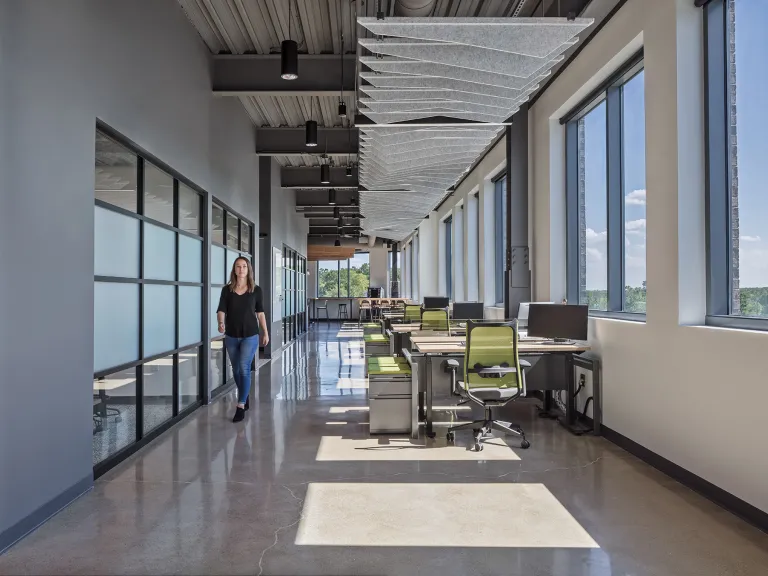 Person walking down a hallway in an industrial style building.