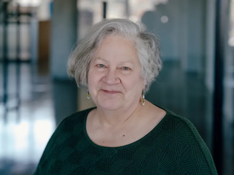 woman wearing dark green sweater in office