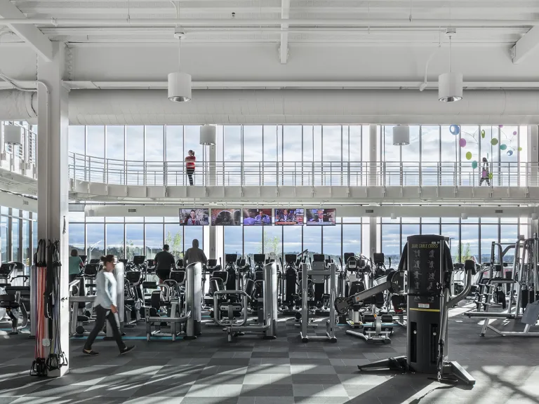 Naturally lit gym area with people exercising.