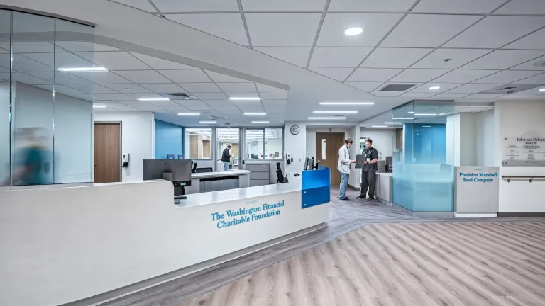 Front desk of The Washington Financial Charitable Foundation, featuring white walls and tinted blue glass accents